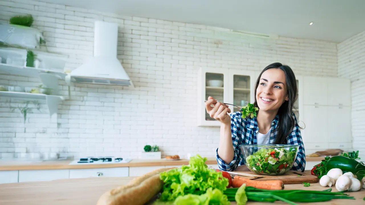 Mujer comiendo ensalada por recomendación de una Técnico en Alimentación y Nutrición.