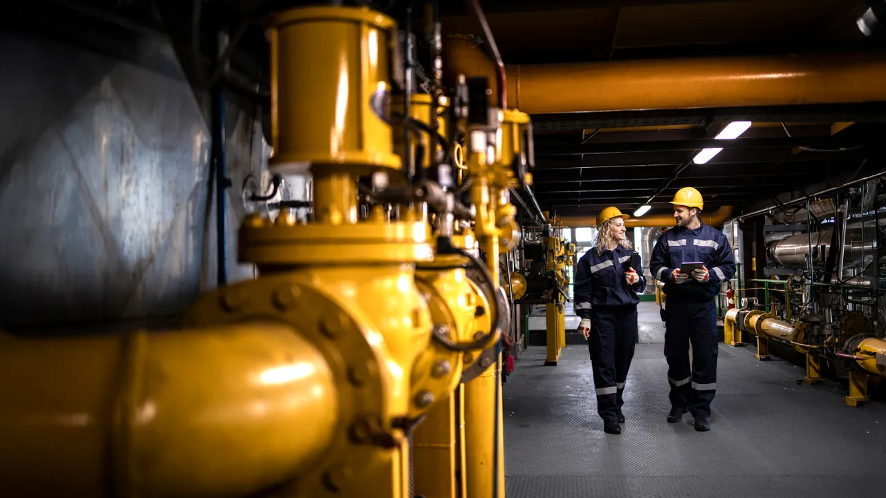 Dos Técnico en Control Industrial revisando maquinaria.