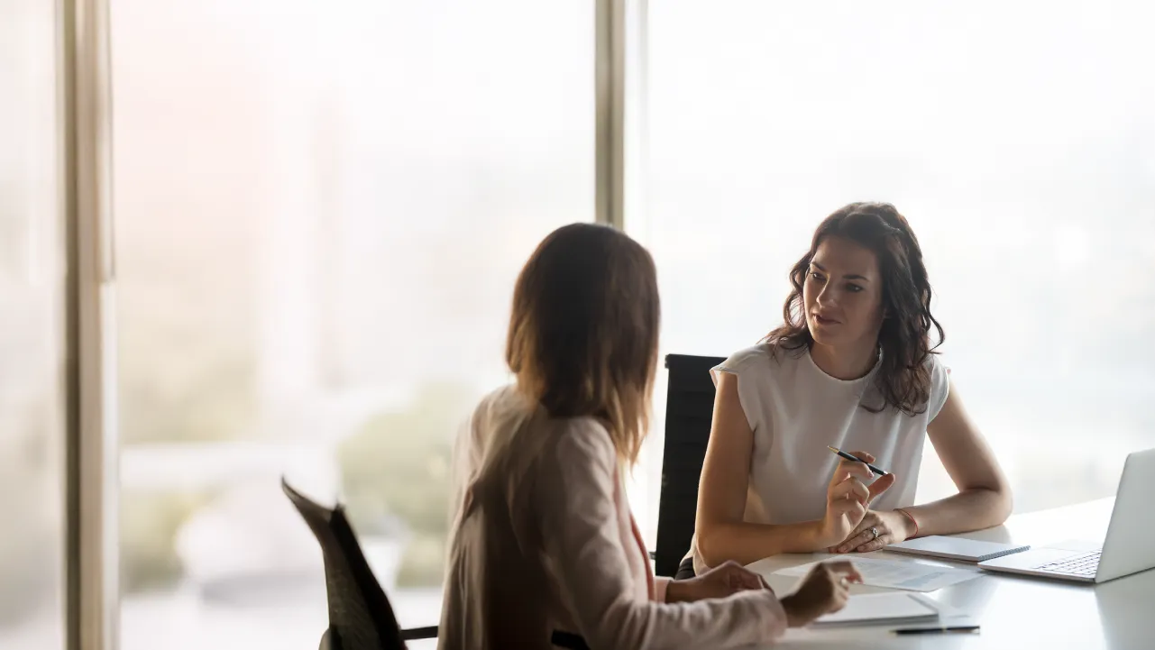 Mujeres conversando en un entorno profesional como parte de una intervención social, representando el rol del trabajo social en contextos reales