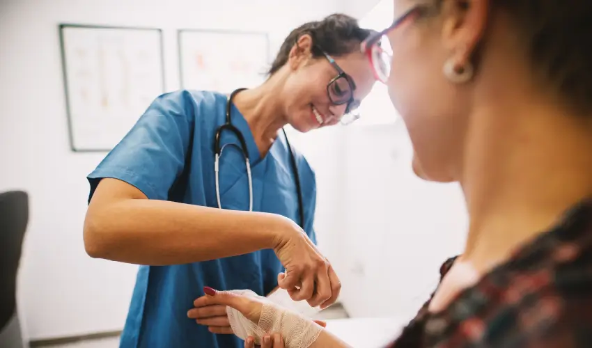 Técnico en Enfermería (TENS) realizando curación a una paciente en centro de salud